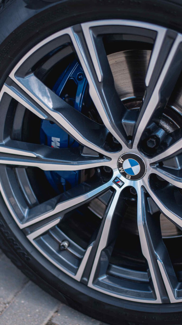 Close up image of a sparkling clean BMW rims and tires with blue brake callipers