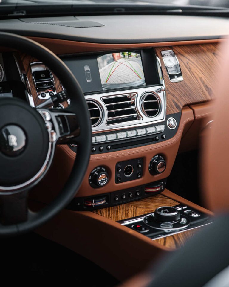 Close up image of car dashboard and instruments, radio, vents and other buttons.